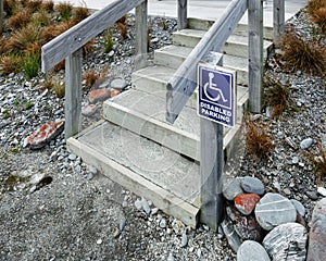 Disabled parking wheelchair sign beside a staircase