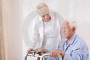 Disabled patient with walking zimmer photo