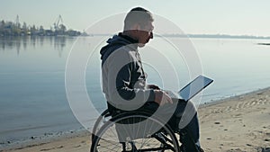 Disabled person with laptop, on wheel chair leads video chat, alone