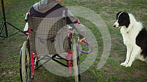 A disabled person plays with a dog, canitis therapy, disability treatment through training with a dog, Man in a