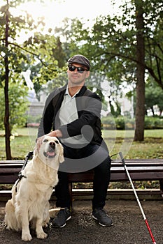 Disabled person sit having rest with dog guide outdoors