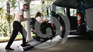 Disabled person on wheelchair using van ramp