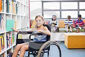 Disabled school girl selecting a book from bookshelf in library