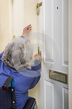 Disabled Senior Lady trying to open a door.