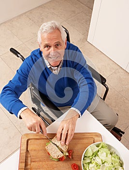 Disabled Senior Man Making Sandwich In Kitchen