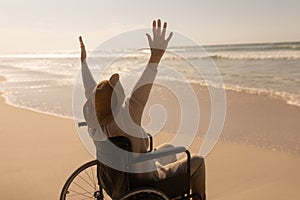 Disabled senior woman with arms up on the beach