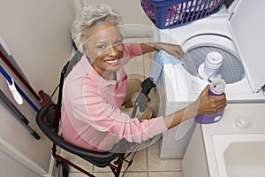 Disabled Senior Woman Doing Laundry At Home photo