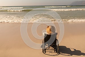 Disabled senior woman looking at ocean on the beach