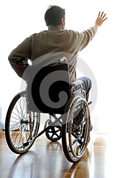 Disabled sitting in a wheelchair in the room near the window