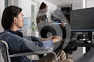 Disabled software developer typing programming code on computer
