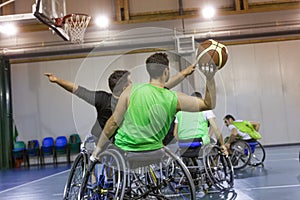 Disabled sport men in action while playing indoor basketball