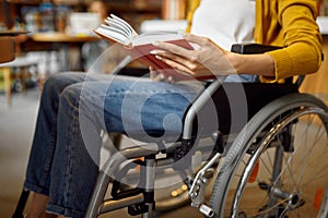 Disabled student in wheelchair reading a book