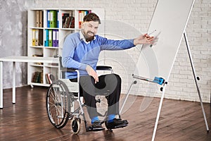 Disabled team leader using a board to draw chart and explaining