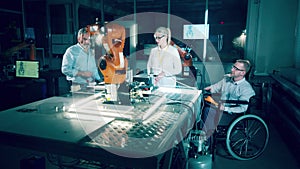 Disabled technician and his coworkers in a modern robotics lab
