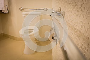 Disabled toilet bathroom with grab bars in white interior design hotel