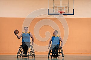 Disabled War veterans mixed race and age basketball teams in wheelchairs playing a training match in a sports gym hall