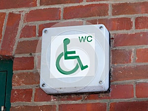 Disabled wc toilet water closet sign outside on brick wall close