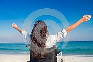 Disabled woman with arms outstretched at the beach