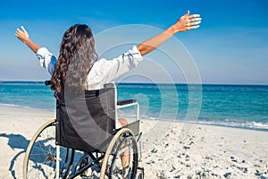 Invalidní žena paže roztažen na pláž 