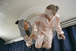 Disabled Woman and Asian Friend Using Stairlift, Caregiver, Carer, Real, Health Care