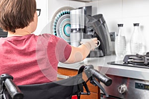 Disabled woman getting coffee in the kitchen