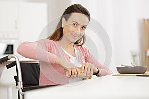 disabled woman having meal in kitchen