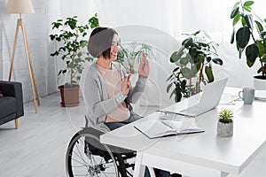 Disabled woman in headset showing okay