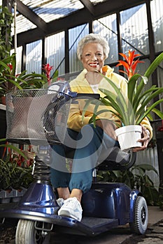 Disabled Woman On Motor Scooter With Plant At Botanical Garden