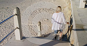 Disabled woman moving downstairs in the beach 4k