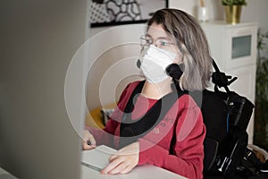 Disabled woman with muscular dystrophy working in front of a computer