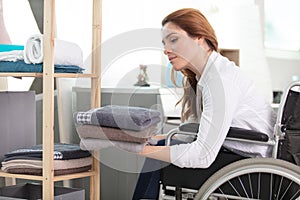 disabled woman putting away laundry in bathroom