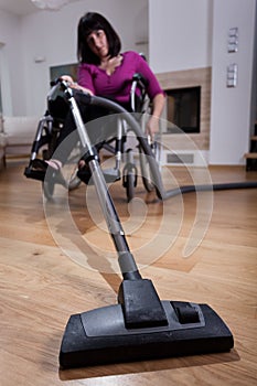 Disabled woman using vacuum cleaner