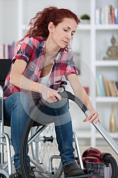 Disabled woman using vacuum cleaner at home