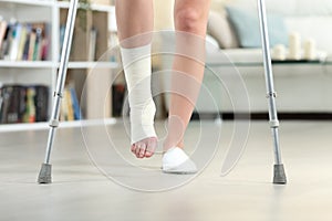 Disabled woman walking with crutches and sprained ankle