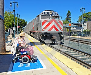Disabled woman watching her train arrive photo