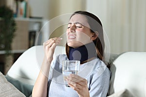 Disabled woman wearing neck brace taking pill