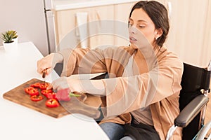 Disabled woman in wheelchair chopping papear