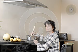 Disabled woman in wheelchair cooking dinner