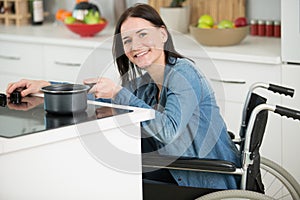 disabled woman in wheelchair preparing meal in kitchen