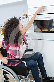 disabled woman in wheelchair preparing meal in kitchen