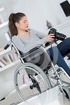 Disabled woman in wheelchair using camera