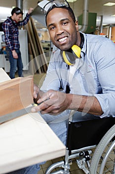 disabled worker in wheelchair as carpenter