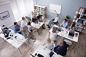 Disabled Young Businessman Giving Presentation To His Colleague