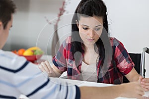 Disabled young female playing chess with friend at home