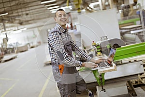 Disabled young man with artificial leg is working at the furniture factory