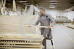 Disabled young man with artificial leg is working at the furniture factory