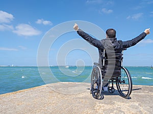 Invalidní mladý muž v invalidní vozík vzhled na more 