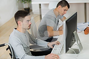 Disabled young man in wheelchair doing homework