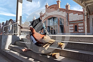 Disabled young man in a wheelchair falls down some stairs