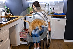 Woman in wheelchair in kitchen at home